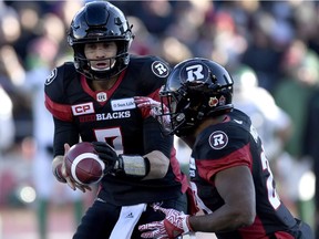 Redblacks tailback William Powell, right, takes a handoff from QB Trevor Harris for one of his eight carries in Sunday's loss to the Roughriders. THE CANADIAN PRESS/Justin Tang