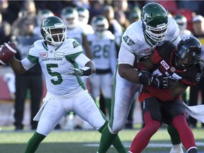 Saskatchewan Roughriders quarterback Kevin Glenn (5) throws the ball as teammate Thaddeus Coleman (68) controls Ottawa Redblacks' Jonathan Newsome (43) during second half Eastern semifinal CFL action in Ottawa on Sunday, Nov. 12, 2017.