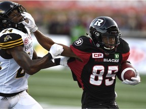 Redblacks returner/receiver Diontae Spencer (85) fends off the Tiger-Cats' Demond Washington in a game on Sept. 9. THE CANADIAN PRESS/Justin Tang