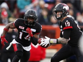 Calgary Stampeders quarterback Bo Levi Mitchell prepares to hand off to running back Roy Finch.