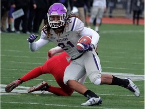 Western's Cederic Joseph eludes an Acadia defender as he rushes the ball during the Uteck Bowl on Saturday at Wolfville, N.S. THE CANADIAN PRESS/Ted Pritchard