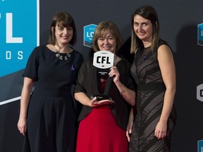 Sara Sowieta, left to right, Jenny Sowieta and Katie Curran hold the Commissioner's Award that was presented in memory of Rick Sowieta during the CFL awards in Ottawa on Thursday.