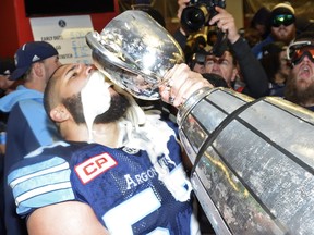 Argonauts offensive lineman Tyler Holmes drinks from the Grey Cup after his team won a CFL championship in his hometown on Sunday. NATHAN DENETTE/The Canadian Press