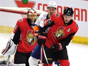 Senators defenceman Dion Phaneuf and Islanders defenceman Anders Lee crowd the net in front of Ottawa goalie Craig Anderson in the first period of Saturday's game. THE CANADIAN PRESS/Justin Tang