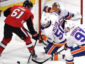 New York's Adam Pelech tries to keep the puck from Ottawa's Mark Stone during the third period of play at Canadian Tire Centre on Saturday night. THE CANADIAN PRESS/Justin Tang