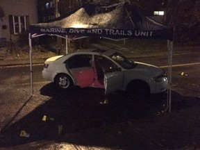 Ottawa police identification officers worked past 7 p.m. Thursday on a vehicle connected to a shooting at the north end of Rochester Street. Barely visible in the photo is a shattered window on the driver’s door. The nine small pyramids on the road indicate where evidence was collected.