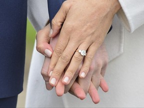 Meghan Markle wears her engagement ring as she poses with Britain's Prince Harry for the media in the grounds of Kensington Palace in London, Monday Nov. 27, 2017. It was announced Monday that Prince Harry, fifth in line for the British throne, will marry American actress Meghan Markle in the spring, confirming months of rumors. (Dominic Lipinski/PA via AP)