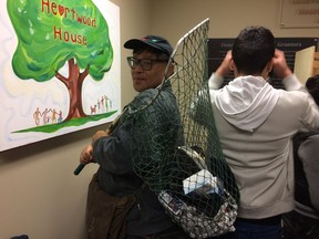 Happy shopper Edward Kwan shows off his finds in his fishing net at the OC Transpo Lost and Found sale Saturday at Heartwood House.