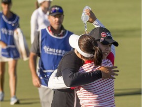 Ariya Jutanugarn, middle, is embraced by her sister Moriya Jutanugarn after sinking a birdie putt on the 18th hole to claim outright victory during the final round of the CME Group Tour Championship on Sunday. Luke Franke/Naples Daily News via AP