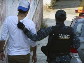 A federal police officer detains a man after a shootout broke out between police and gunmen on a central avenue in downtown Acapulco, Guerrero state, Mexico, Sunday, Nov. 12, 2017. Mexican authorities say eight people have been killed and five more bodies found in a clandestine grave Sunday in Acapulco, in a particularly bloody day even for the violence-plagued Pacific Coast resort city.(AP Photo/Bernandino Hernandez) ORG XMIT: MXBH103
Bernandino Hernandez, AP
