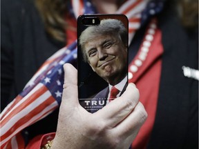 FILE - In this Thursday, Sept. 29, 2016, file photo, a woman holds up her cell phone before a rally with then presidential candidate Donald Trump in Bedford, N.H. President-elect Trump tweeted Tuesday that North Korea won't develop a nuclear weapon capable of reaching parts of the United States, but it's possible it already has. After five atomic test explosions and a rising number of ballistic missile test launches, many experts believe that North Korea can arm short- and mid-range missiles with warheads that put Guam at risk. (AP Photo/John Locher, File) ORG XMIT: BKWS310

THURSDAY, SEPT. 29, 2016, FILE PHOTO
John Locher, AP