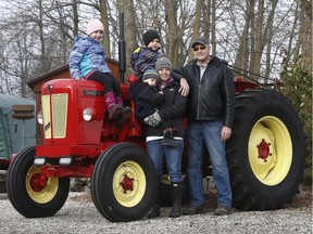 Mike Thompson stands with Jillian O'Connor and her kids Mya, Landon and Declan near Mississippi Mills Ontario Friday Nov 24, 2017. Mike Thompson drove his tractor around Ontario to raise money for an education fund for Jillian's kids. Jillian is battling terminal cancer.