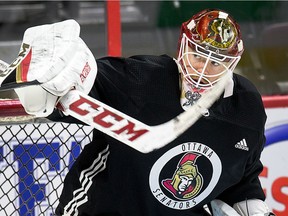 Goalie Mike Condon deflects a puck away as the Ottawa Senators practice at Canadian Tire Centre.