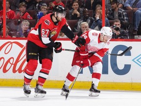 Ben Harpur of the Ottawa Senators has his stick held by Gustav Nyquist of the Detroit Red Wings on Oct. 7, 2017