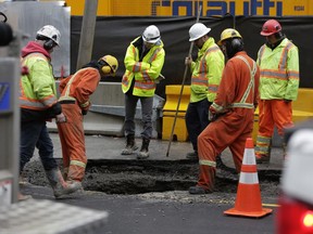 Workers at a new sinkhole on Rideau Street near the 2016 cave-in.