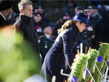 Sophie Grégoire Trudeau, wife of Prime Minister Justin Trudeau, lays a wreath as Minister of National Defence Harjit Sajjan, left, and Minister of Veterans Affairs and associate minister of National Defence Seamus O'Regan look on during the National Remembrance Day Ceremony at the National War Memorial in Ottawa on Saturday, Nov. 11, 2017.
