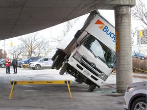 A rental truck being used by Canada Post managed to get stuck under a parking lot ramp at the St Laurent Shopping Centre.  The driver was following a detour around some road construction in the parking area adjacent to St Laurent Blvd and found himself driving under the ramp that didn't have enough clearance.
