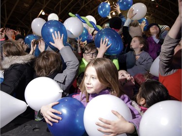 Children scoop up large balloons at the Aberdeen Pavilion as Lansdowne Park as the clock strikes 7 p.m. in Ottawa, which was midnight in Scotland.