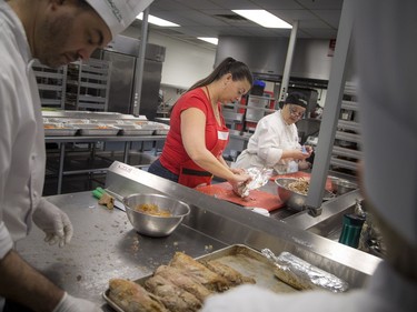 Volunteers, students and chefs were busy preparing a festive meal in support of Operation Big Turkey at the Algonquin College School of Hospitality Kitchen Saturday December 23, 2017. The thirteenth year of Operation Big Turkey has over 200 volunteers coming together to make 2500 turkey dinners to anyone who would like to have a meal.  L-R Vanessa Simmons and Angela Ierullo working on the turkey breasts, getting them prepared for the dinners.   Ashley Fraser/Postmedia