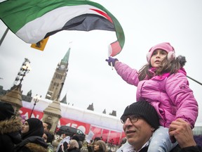 Supporters gathered outside the US Embassy then marched to the Embassy of Israel on O'Connor Street Saturday December 9, 2017. Seven-year-old Maya Abusneineh waves a Palestine flag as the group marched along Wellington Street