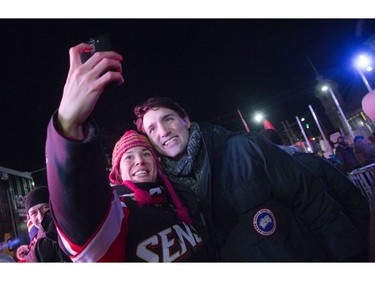Prime Minister Justin Trudeau poses for a selfie with a hockey fan.