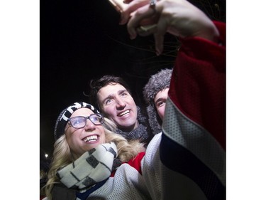 Prime Minister Justin Trudeau poses for a selfie with hockey fans before the game.