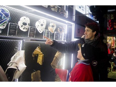 Prime Minister Justin Trudeau looks at NHL memorabilia with his son, Xavier.