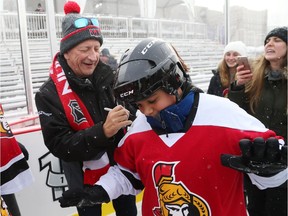 Eugene Melnyk, owner of the Ottawa Senators, signs an autograph to one of the students who attended his annual Skate for Kids on the outdoor rink on Parliament Hill in Ottawa, December 10, 2017.