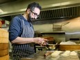 Chef Tarek Hassan prepares steamed buns stuffed with pork at The Cauldron Kitchen. Hassan is crowdfunding for his new Bank Street restaurant, set to open next year.