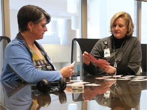 Kimberley Hawkins, left and Susan Barnes, both staff at the Queensway Carleton Hospital, take part in the "hearing voices" audio while performing simple tasks so they know how it feels to have psychotic disorders.