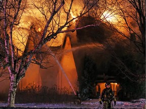 A church on Slack Road burns behind a firefighter.