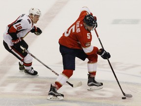 Florida Panthers' Aaron Ekblad moves the puck as Ottawa Senators' Ryan Dzingel defends during Saturday night's game.