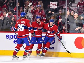 Paul Byron, right, receives congratulations from Canadiens teammates Jacob de la Rose (25) and Victor Mete after scoring a second-period goal against the Red Wings.