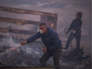 SUNLAND, CA - DECEMBER 05: Residents hose their burning property during the Creek Fire on December 5, 2017 in Sunland, California. Strong Santa Ana winds are rapidly pushing multiple wildfires across the region, expanding across tens of thousands of acres and destroying hundreds of homes and structures.