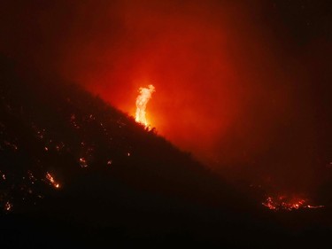 OJAI, CA - DECEMBER 06:  Flames shoot in the air as fires burn in the mountains on December 6, 2017 near Ojai, California. Strong Santa Ana winds are rapidly pushing multiple wildfires across the region, expanding across tens of thousands of acres and destroying hundreds of homes and structures.