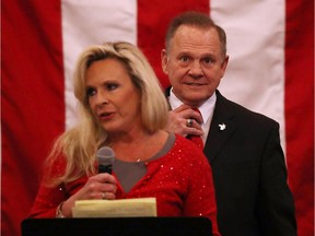 Republican Senatorial candidate Roy Moore stands behind his wife Kayla Moore as she speaks during a campaign event at Jordan's Activity Barn on December 11, 2017 in Midland City, Alabama. Mr. Moore is facing off against Democrat Doug Jones in tomorrow's special election for the U.S. Senate.