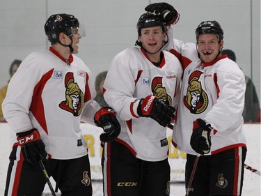 Colin Greening (L), Zach Smith and Chris Neil (R) of the Ottawa Senators celebrate their goal during practice at the Bell Sensplex in Ottawa, January 20, 2013.