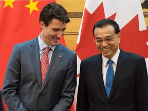 Prime Minister Justin Trudeau and China's Premier Li Keqiang smile during a ceremony at the Great Hall of the People in Beijing Monday.
