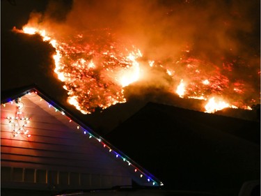 A wildfire burns along a hillside near homes in Santa Paula, California, on December 5, 2017. Fast-moving, wind-fueled brush fire exploded to about 10,000 acres in Ventura County Monday night, forcing hundreds of people to flee their homes, officials said.