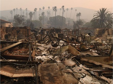 TOPSHOT - Trees are seen through the haze at the burnt out Vista del Mar Hospital after the Thomas wildfire swept through Ventura, California on December 6, 2017. California motorists commuted past a blazing inferno Wednesday as wind-whipped wildfires raged across the Los Angeles region, with flames  triggering the closure of a major freeway and mandatory evacuations in an area dotted with mansions.