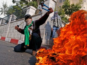 A Palestinian protestor uses a sling shot to throw stones towards Israeli security forces during clashes after the Friday prayers in the city centre of the West Bank town of Hebron on December 8, 2017. Palestinians clashed with Israeli security forces after calls for a "day of rage" as US President Donald Trump's declaration of Jerusalem as Israel's capital sent shockwaves through the region for a second day. (AFP/Getty Images/HAZEM BADER)