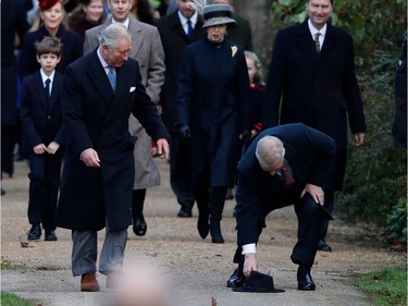 Britain's Prince Andrew, Duke of York, (front R) stoops to pick up the hat of a well-wisher next to Britain's Prince Charles, Prince of Wales (front L) as they lead other members of the family to attend the Royal Family's traditional Christmas Day church service at St Mary Magdalene Church in Sandringham, Norfolk, eastern England, on December 25, 2017.