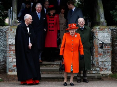 Britain's Queen Elizabeth II (C) and Britain's Prince Philip, Duke of Edinburgh (R) lead out other members of the family with Reverend Canon Jonathan Riviere (L) as they leave after attending the Royal Family's traditional Christmas Day church service at St Mary Magdalene Church in Sandringham, Norfolk, eastern England, on December 25, 2017.