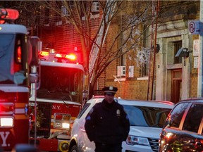 A New York Police Department officer works on the scene of an apartment fire on December 29, 2017 in the Bronx borough of New York City. Officials said Friday that the death toll from the fire has reached 12, including four children.