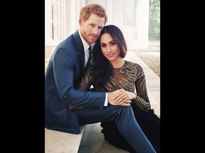 In this photo released by Kensington Palace on Thursday, Dec. 21, 2017, Britain's Prince Harry and Meghan Markle pose for one of two official engagement photos, at Frogmore House, in Windsor, England.