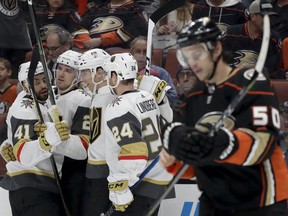 Members of the Vegas Golden Knights celebrates after a goal by defenseman Shea Theodore as Anaheim Ducks center Antoine Vermette skates by during the first period of an NHL hockey game in Anaheim, Calif., Wednesday, Dec. 27, 2017.