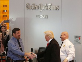 Donald Trump shakes hands with a security guard as he leaves the New York Times building following a meeting on Nov. 22, 2016, in New York. His frequent criticism of the Times and other stalwart media organizations hasn't stopped the newspaper from breaking story after story.