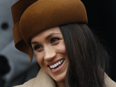 Meghan Markle fiancee of Prince Harry smiles as she waits for the Queen to leave by car following the traditional Christmas Day church service, at St. Mary Magdalene Church in Sandringham, England, Monday, Dec. 25, 2017.