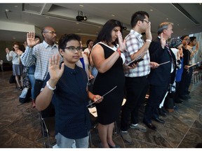 Luiz capitulino,11, of Brazil joins others in the oath as they become official Canadians during a citizenship ceremony at the National Arts Centre in Ottawa on Monday, Sept. 25, 2017.