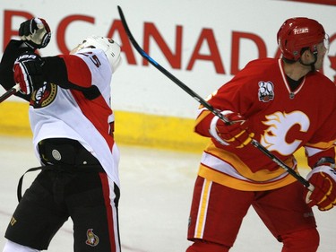 Ottawa's Chris Neil gets clipped by the stick of Calgary's Cory Sarich during the first period at the Sadledome March 11.